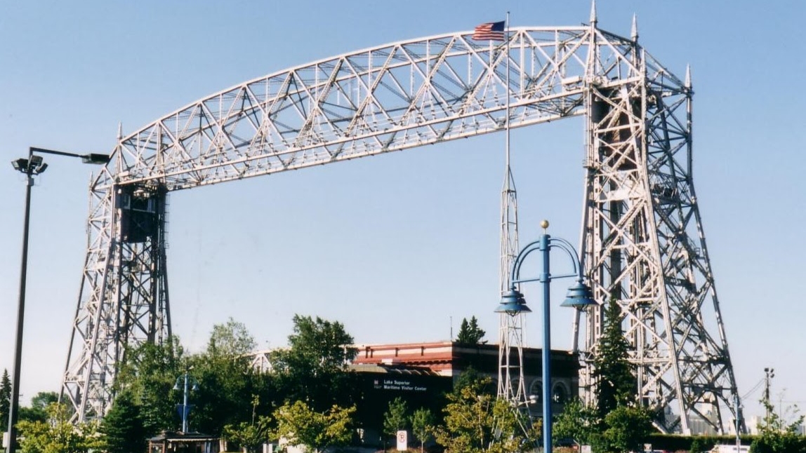 Duluth Aerial Lift Bridge towers and raised span above Canal Park trees and lamps