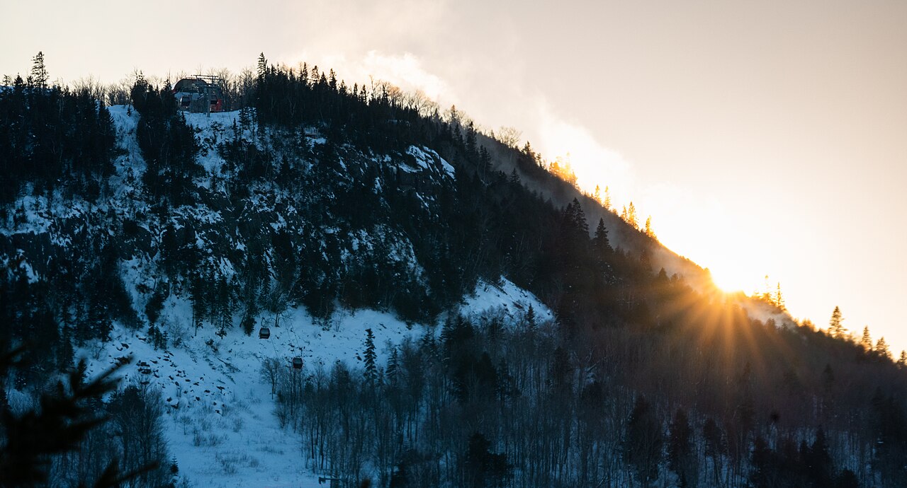 Winter sunlight behind the wooded ski hill and gondola at Lutsen Mountains